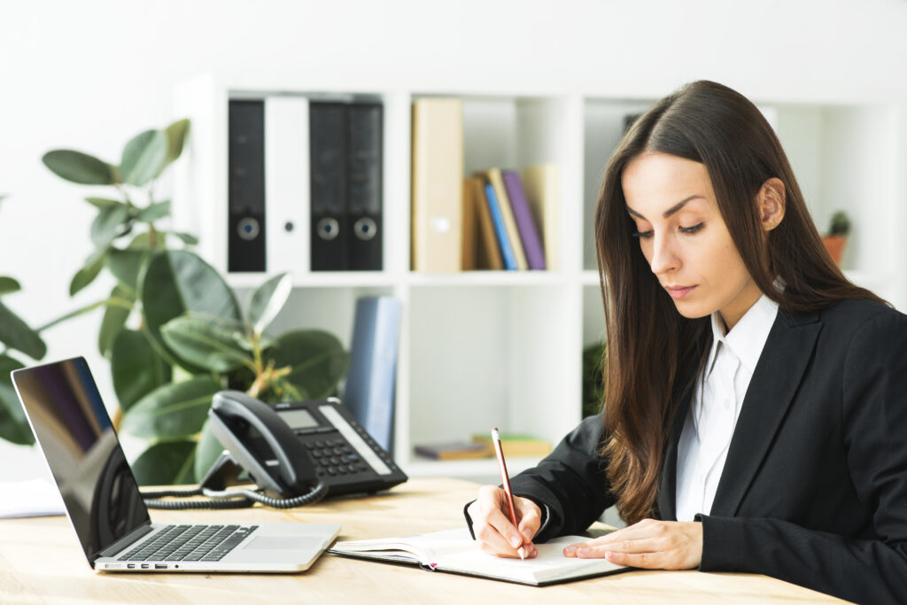 mujer escribiendo en escritorio