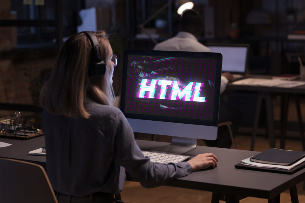 joven frente a monitor donde visualiza la palabra html